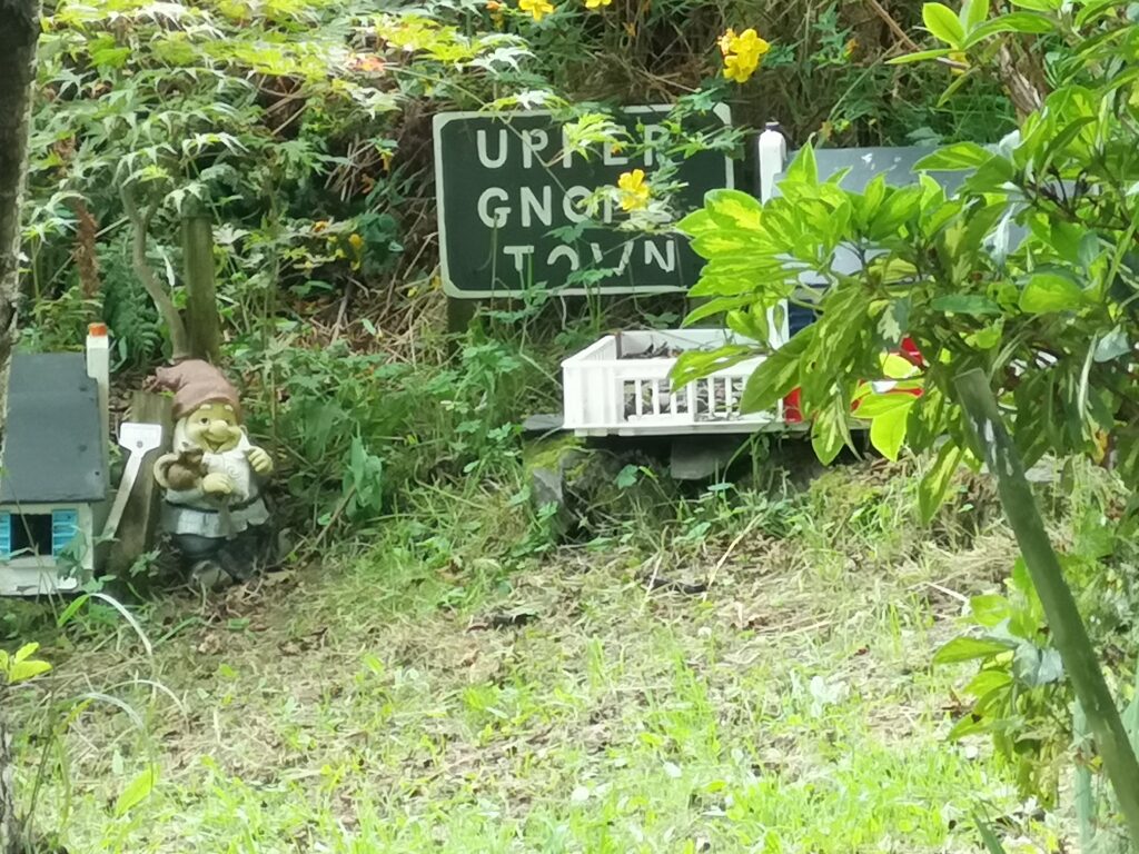 Eine kleine Zwergenstadt am Rande bei Rhu Beach, vesteckt unter Bäumen sieht man kleine Zwerge und selbst gebaute Häuser stehen.Hier ist noch ein Schild zu sehen mit Aufschrift: Upper Gnom Town