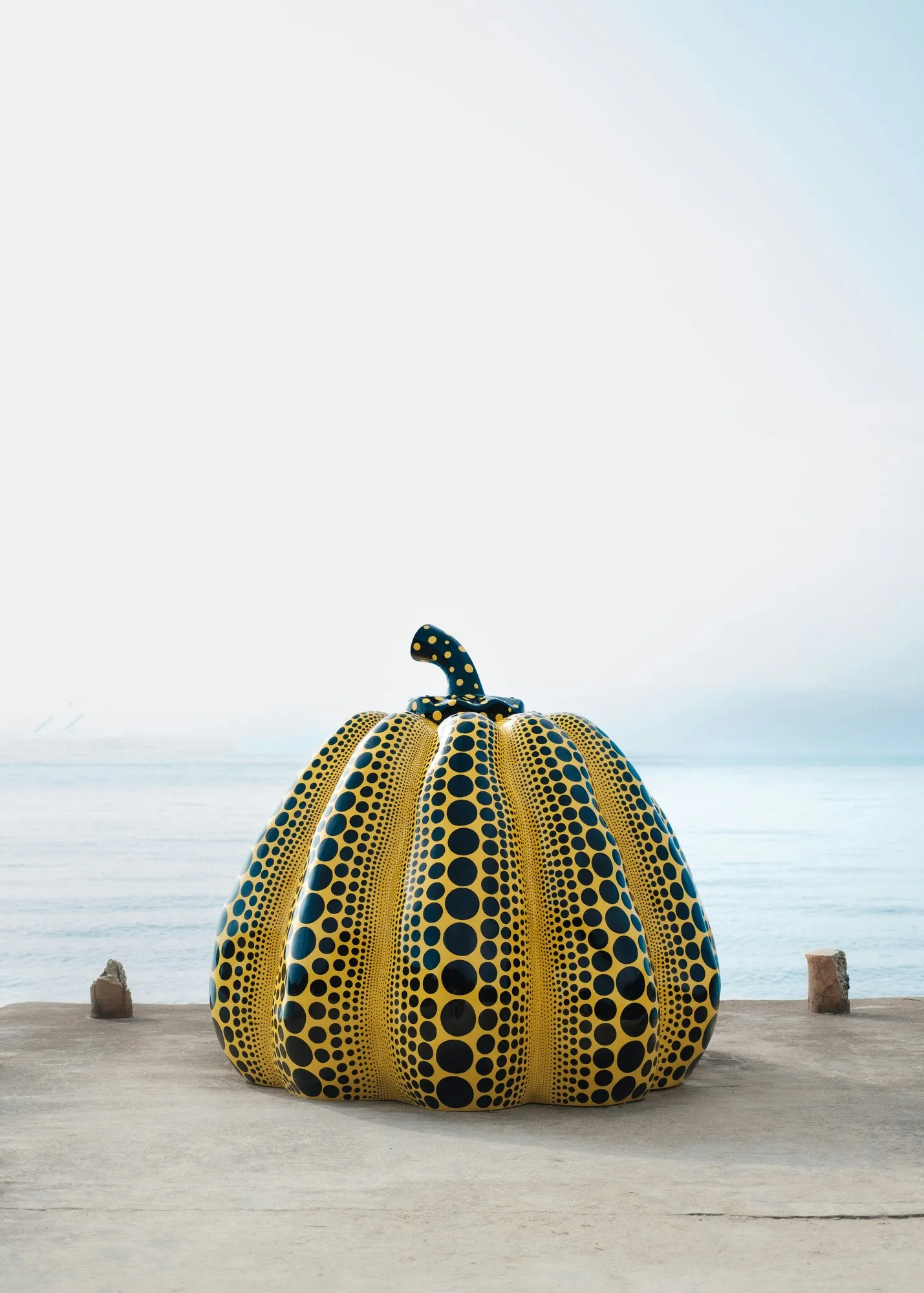 Yayoi Kusama’s yellow and black polka-dot Pumpkin on a concrete pier beside the sea on Naoshima, Japan