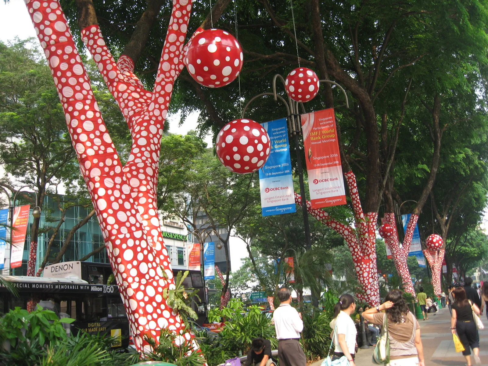 Trees wrapped in red fabric with white polka dots for Yayoi Kusama’s Ascension of Polka Dots on the Trees in Singapore