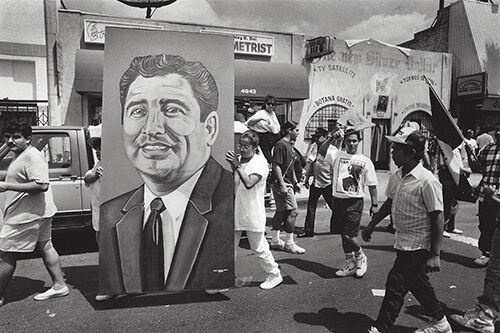 A procession bearing a large portrait of Ruben Salazar.
