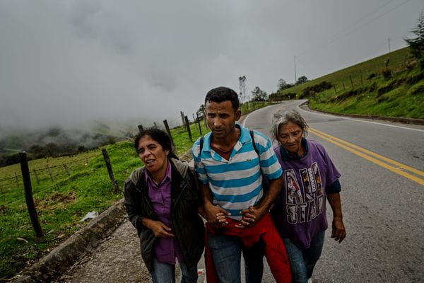 Luis Mario Fuenmayor Alfaro grabs on to Liliana Mendoza and Eva Alfaro Aldana to help them walk